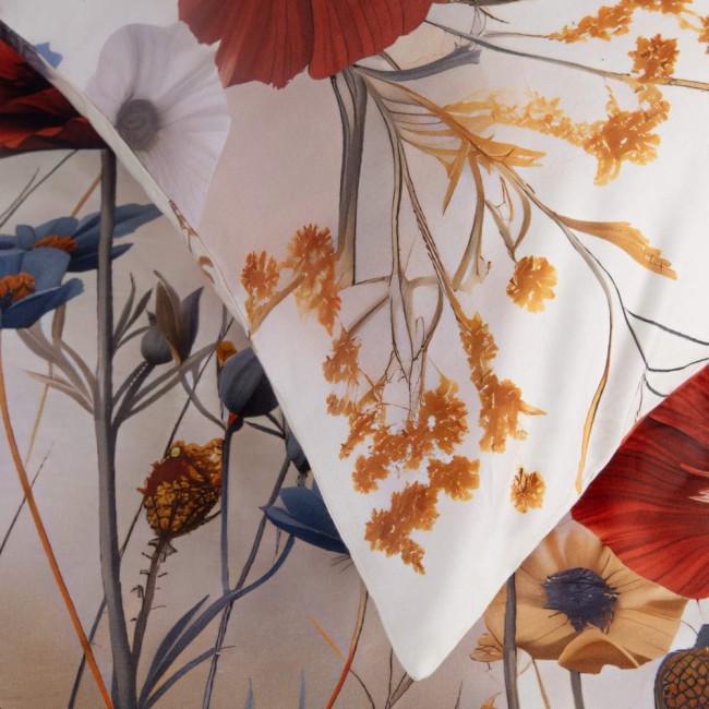 Pościel satynowa 180x200, zestaw z poduszką, w kolorze kremowym z wzorem polnych czerwonych i niebieskich kwiatów, rozłożona na jaśniejszym tle. Widoczne eleganckie detale, takie jak delikatne cieniowanie i tekstura materiału.