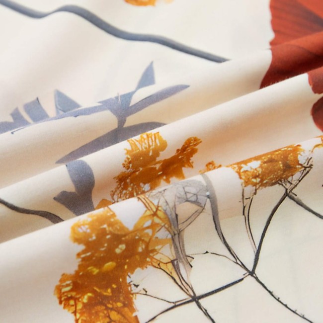 Pościel satyna bawełniana 180x200 w kolorze jasnym, z delikatnym nadrukiem polnych czerwonych kwiatów oraz szarych liści na całości. Ułożona w formie złożonej, pokazująca teksturę materiału. Idealna do stylowej sypialni.