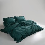 Pościel bawełniana z falbanką w kolorze zieleni butelkowej. Zestaw składa się z poszwy na kołdrę i dwóch poduszek, wszystkie z falbaniastym wykończeniem. Produkt leży na łóżku, całkowicie rozłożony, na jednolitym, jasnym tle.