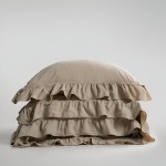 Pościel bawełniana z falbanką 220x200 Stonewashed Exclusive w kolorze beżowym, leżąca na płaskiej powierzchni. Widoczne falbanki na dwu warstwach pokrycia. Materiał o matowej, teksturowanej fakturze, dopasowany do eleganckiego wystroju wnętrza.