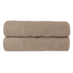 Komplet ręczników Solano w kolorze beżu, wykonany z bawełny. Złożone w stosie, ukazują delikatną fakturę oraz szlufkę z dekoracyjnym wzorem w romby. Widoczna wysoka jakość materiału. Idealne do łazienki lub jako prezent w eco pudełku.