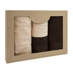 Komplet ręczników z bawełny Solano w eco pudełku zawiera trzy ręczniki w kolorach: jasnym beżowym, kremowym i ciemnym brązowym. Ręczniki są złożone, z widocznymi eleganckimi detalami w postaci haftów. Pudełko ma naturalny wygląd, z logo DARYmex na górze.