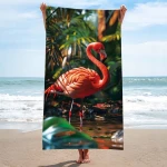 Ręcznik plażowy 100x180 cm z mikrofibry w różowym kolorze, wizualizujący flaminga na tle tropikalnej roślinności. Produkt rozłożony, trzymany w dłoniach, ukazuje szczegóły wzoru flaminga oraz fakturę materiału. Tło z morzem i piaskiem.