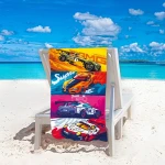 Ręcznik plażowy 100x180 cm z motywem sportowych aut w intensywnych kolorach: pomarańczowym, niebieskim i różowym. W leżącej pozycji na leżaku, w tle błękitne morze i piasek. Wzór przedstawia szczegóły samochodów wyścigowych, szybko schnący z mikrofibry.
