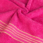 Ręcznik kąpielowy 50x90 cm w intensywnym różowym kolorze, wykonany z bawełny o gramaturze 500 g/m², z dekoracyjną bordiurą w złote paski. Produkt leży na płaskiej powierzchni, ukazując fakturę materiału.