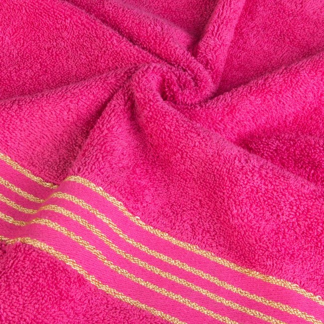 Ręcznik kąpielowy 50x90 cm w intensywnym różowym kolorze, wykonany z bawełny o gramaturze 500 g/m², z dekoracyjną bordiurą w złote paski. Produkt leży na płaskiej powierzchni, ukazując fakturę materiału.