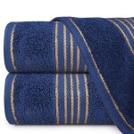 Ręcznik kąpielowy 70x140 cm w ciemnym niebieskim kolorze, wykonany z bawełny, o gramaturze 500 g/m², z bordiurą w złote paski. Ułożony w poziomie, w zbliżeniu na detale tekstury materiału.