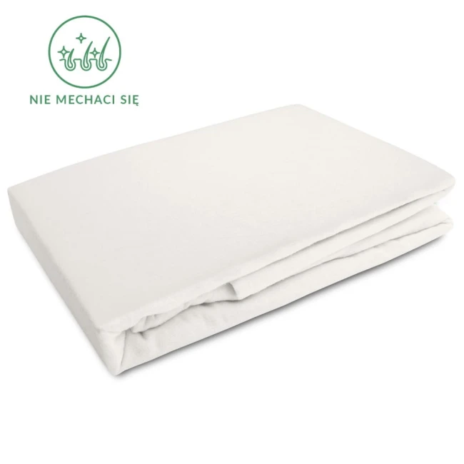 Prześcieradło flanelowe z gumką 120x200 w kolorze kremowym, leżące rozłożone na białym tle. Materiał o gramaturze 160 g/m², z gładką powierzchnią. Widoczna etykieta z napisem „Nie mechaci się”. Produkt bez wzorów i zdobień.