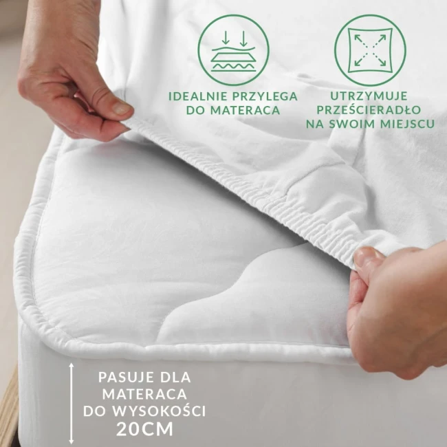 Prześcieradło flanelowe z gumką 120x200 w kolorze jasnego beżu, z widoczną elastyczną krawędzią. Ułożone na materacu, w zbliżeniu na detal gumki, która idealnie przylega do materaca o wysokości 20 cm. Na tle neutralnym, bez dodatkowych elementów.