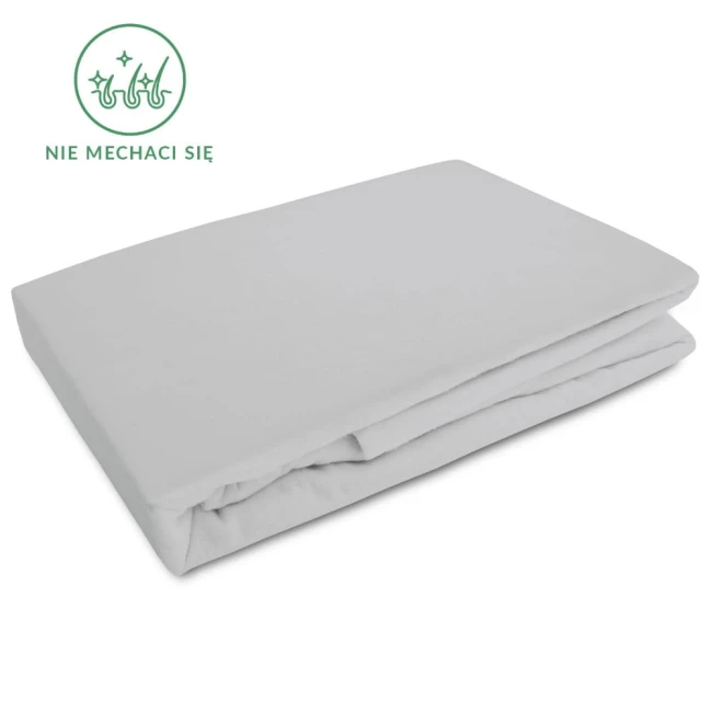 Prześcieradło flanelowe z gumką w kolorze jasno szarym, rozmiar 120x200 cm, leżące na białym tle. Materiał o gramaturze 160 g/m², z miękką fakturą. Widoczny tekst NIE MECHACI SIĘ oraz gumka zabezpieczająca.