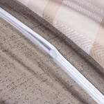 Pościel bawełniana 140x200 Linea w beżowe pasy i kratkę, widok z góry, z zamkiem błyskawicznym. Tło jasne, widać fakturę materiału w odcieniach beżu z wzorami. Zamek jest biały, a materiał gładki i przyjemny w dotyku.