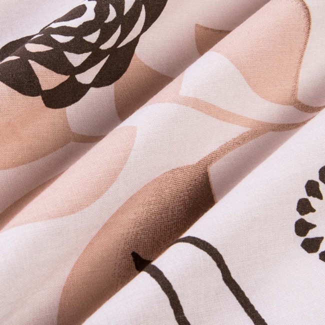 Pościel bawełniana w rozmiarze 140x200 w beżowe kwiaty, wykonana z miękkiego materiału. Kąt ujęcia zbliżony na detale, pokazujący wzór oraz delikatne faktury tkaniny. Tło jasne, co eksponuje kolory i motywy.