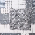 Pościel flanelowa 180x200 Ardela Grey w kolorze szaro-białym, z różnorodnymi wzorami: kratką, liniami i okręgami. Materiał miękki, z teksturą flaneli. Zdjęcie ukazuje fragment materiału z bliska, akcentując detale splotu oraz kolory.