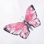 Różowy motyl z wyraźnymi detalami na skrzydłach na białym tle. Motyl ma niebieskie akcenty oraz delikatne cieniowanie, co podkreśla jego kształt. Widok z boku, zbliżenie na wzór.