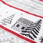 Pościel flanelowa 180x200 Selvia w bieli z wzorem choinek i chatki, z czerwonymi i szarymi akcentami, leżąca na płaskiej powierzchni. Widoczna struktura materiału oraz detale graficzne przedstawiające świąteczne motywy.