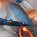 Pościel satyna bawełniana 160x200 Auroria z motywem złotych kwiatów na niebieskim tle. Ułożona w lekkim zarysie, z widoczną fakturą oraz wykończeniem brzegów. Tło zdjęcia jest neutralne, co podkreśla detale wzoru i kolory.