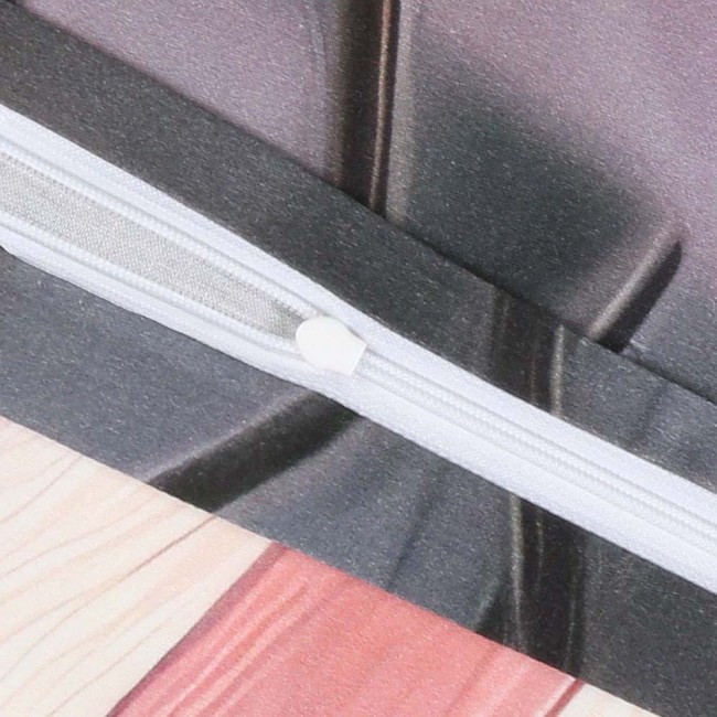 Zbliżenie na zamek błyskawiczny białego koloru, umieszczony na pościeli satynowej w pastelowych odcieniach różu z kwiatowym wzorem. Tło w neutralnym odcieniu, prezentujące teksturę materiału. Widać detale wykończenia i przeszycia.