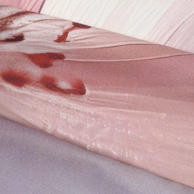 Pościel satyna bawełniana o wymiarach 180x200 cm, w pastelowych różowych kwiatach. Tkanina o delikatnym, gładkim wykończeniu, leżąca na prostym tle. Widoczne złożenie materiału ukazujące wzory kwiatowe na beżowym tle.