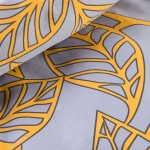 Pościel satyna bawełniana o wymiarach 140x200 cm, wzór z pomarańczowymi liśćmi na szarym tle. Produkt leży na płaskiej powierzchni, zbliżenie ukazuje szczegóły wzoru i teksturę materiału. Widoczne kontury liści oraz ich wyraźny kolor kontrastują z tłem.