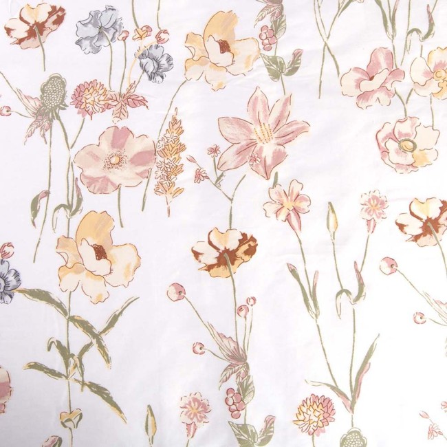Pościel z satyny bawełnianej 140x200 z delikatnym kremowym wzorem kwiatów na białym tle. Ułożona na płasko, z widocznymi szczegółami roślinności, w tym lilii, maków i innych drobnych kwiatów. Tło jest jednolite, co podkreśla kolorystykę.