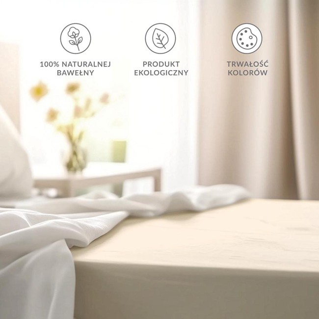 Prześcieradło bawełniane bez gumki w kolorze kremowym, rozłożone na materacu. Ujęcie z boku, z widoczną miękką fakturą materiału. W tle jaśniejsze tkaniny oraz elementy wystroju wnętrza. Na boku dodatkowe 5 cm materiału.