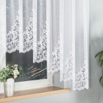 Firana gotowa BERENIKA w kolorze białym, wykonana z żakardowego materiału, o wymiarach 400x160 cm. Zawieszona na oknie, z dekoracyjnym, ażurowym wzorem na dolnej krawędzi. Tło z drewnianą półką i doniczką z rośliną.