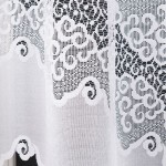Firana gotowa MODESTA, żakardowa, biała, o wymiarach 300x160 cm. Widoczne wzory w formie falistych linii oraz delikatne ornamenty. Zdjęcie przedstawia produkt w zbliżeniu, wiszący, z lekko transparentnym materiałem na jednolitym tle.