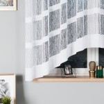 Firana gotowa WIKTORIA, żakardowa, biała, o wymiarach 310x160 cm. Zawieszona, z delikatnym, wzorzystym splotem. W tle widoczna drewniana półka z dekoracjami oraz neutralne, szare ściany, które podkreślają jasność firany.