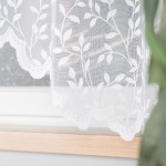 Firanka gotowa ZUZANNA w kolorze białym, żakardowa z motywem liści na całej powierzchni, o wymiarach 300x160 cm. Ujęcie z boku, wisząca na oknie. Zdobienia na brzegu w formie falbany. Tło jasne, podkreślające wzór materiału.