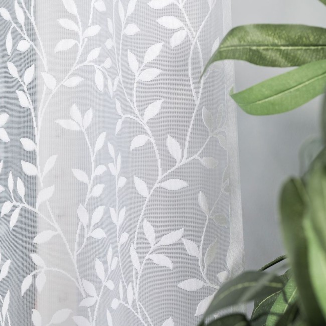 Firana gotowa ZUZANNA żakardowa w kolorze białym, o wymiarach 300x160 cm. Wzór liściowy rozciągający się na całej powierzchni.