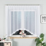 Biała firana gotowa ŻAKLINA żakardowa, 330x160 cm, zawieszona w oknie. Z przodu widoczny haftowany, koronkowy wzór u dołu. Firana przepuszczająca światło, w tle okno z widokiem na zewnątrz, udekorowana kwiatami na parapecie i elementami wystroju wnętrza.