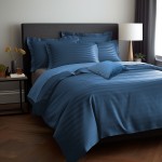 Pościel bambusowa satyna bawełniana 160x200 w kolorze chabrowym z poziomymi paskami, rozłożona na łóżku. W widoku z boku na tle jasnej ściany, z poduszkami i narzutą. Przy łóżku stolik z dekoracjami. Zestaw zawiera różne poduszki.