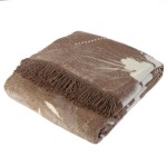 Dwustronny koc bawełniany 150x200 cm w odcieniu brązowym z białymi liśćmi, z frędzlami na krótszym boku. Leży na białym tle, w układzie złożonym, prezentując delikatną fakturę materiału.