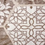 Dwustronny koc bawełniany w rozmiarze 150x200 cm w kolorze beżowym i brązowym, z subtelnym wzorem na mozaikę. Widać frędzle na brzegach. Zdjęcie zbliżeniowe ukazuje szczegóły tkaniny oraz fakturę materiału, na jasnym tle.