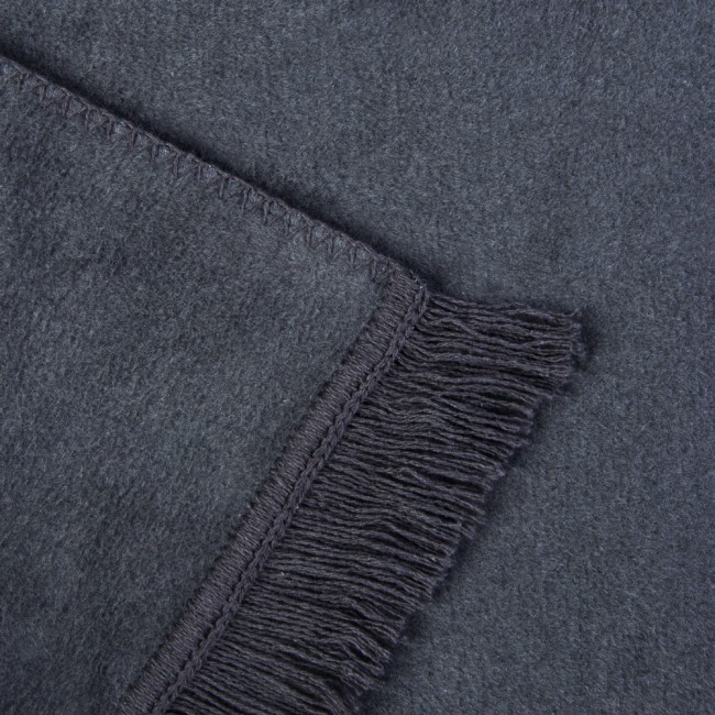 Koc bawełniany 150x200 cm w ciemnoszarym kolorze, z frędzlami na jednym z brzegów. Zdjęcie w zbliżeniu, ukazujące teksturę materiału oraz detale wykończenia. Koc leży na powierzchni o miękkiej fakturze, co podkreśla jego właściwości.