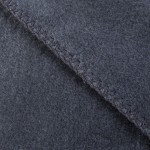 Koc bawełniany o wymiarach 150x200 cm w ciemnoszarym kolorze, z frędzlami, pokazany w zbliżeniu. Widoczna faktura materiału oraz staranne wykończenie brzegów, które są obszyte wzdłuż krawędzi.