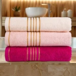 Komplet ręczników z bawełny w eco pudełku kolor jasno różowy z bordiurą w złote paski 500 g/m2 TIWANO 2 kpl.