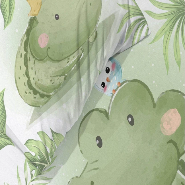 Pościel bawełniana dla dzieci 100x135 cm w zielonym kolorze, z nadrukiem małego krokodyla i ptaszka na tle roślinnych motywów. Widok z góry, złożona na łóżku. Materiał gładki, przyjemny w dotyku. Idealna dla chłopca.