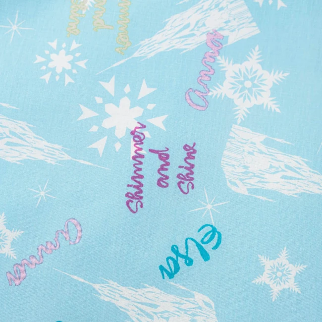 Pościel bawełniana dla dzieci 100x135 w błękitnym kolorze, z motywem Kraina Lodu. Wzór zawiera napisy Anna, Elsa oraz Shimmer and Shine w różnych kolorach, a także białe płatki śniegu i lodowe formacje. Produkt leży na gładkim tle.