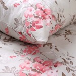 Pościel bawełniana 140x200 w kolorze beżowym z różowymi kwiatami, zestaw składający się z poszwy na kołdrę i poduszki. Wzór kwiatowy na tle w jasnym odcieniu, z widocznymi detalami liści. Pozycja leżąca, na jednolitym tle.