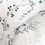 Pościel bawełniana 200x220 See Blossom w kolorze białym z niebieskimi i szarymi kwiatami oraz delikatnymi gałązkami. Materiał jest gładki, a wzór znajduje się na obu stronach. Pościel leży luźno, ukazując detale nadruku.