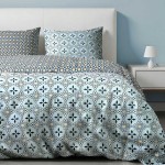 Pościel bawełniana 200x220 w niebieskim kolorze z mozaikowym motywem, zawiera poszewki na poduszki. Produkt leży na łóżku, z widocznym wzorem w różnych odcieniach niebieskiego i żółtego. Tło w jasnym kolorze.