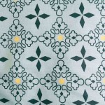 Pościel bawełniana 200x220 w niebieskim kolorze z mozaikowym motywem. Wzór składa się z zielonych i żółtych elementów na jasnym tle, wykonana z materiału Cottonlove Exclusive, leżąca na gładkiej powierzchni.