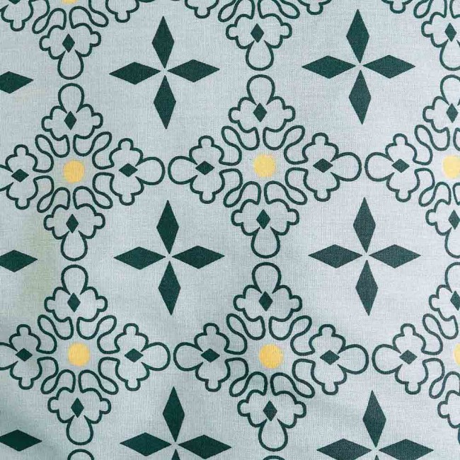 Pościel bawełniana 200x220 w niebieskim kolorze z mozaikowym motywem. Wzór składa się z zielonych i żółtych elementów na jasnym tle, wykonana z materiału Cottonlove Exclusive, leżąca na gładkiej powierzchni.