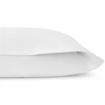 Pościel hotelowa bawełniana 220x200 cm, gładka, biała, z zakładką 30 cm. Widok z boku z leżącego koca, ujawniającego jego prosty, elegancki krój. Tekstura materiału gładka, bez widocznych wzorów czy napisów. Tło białe, minimalistyczne.