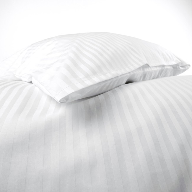 Pościel hotelowa bawełniana 140x200 z białymi pasami o szerokości 1 cm, złożona na łóżku. Widoczne poduszki w kształcie prostokątów z pasami, materiał gładki, bez ozdobnych elementów. Tło białe.