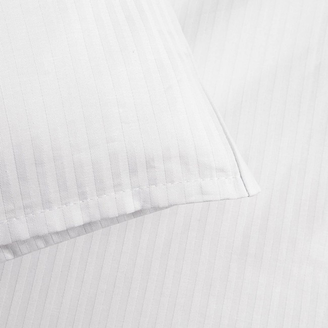 Biała poszewka na poduszkę 50x70 cm z fakturą w pionowe paski o szerokości 4 mm, leżąca na jednolitym tle. Zakończenie na zakładkę, materiał gładki, bez widocznych napisów czy logo. Wzór stonowany, pasujący do różnych aranżacji.