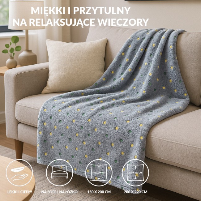 Puszysty koc dekoracyjny w kolorze zielonym malachitowym o wymiarach 200x220 cm, wykonany z miękkiego materiału. Koc leży na jasnej sofie, z widocznymi okrągłymi wzorami w kolorach żółtym i zielonym.