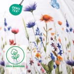 Pościel flanelowa 180x200 Florina Snow w kolorze białym z nadrukiem kolorowych kwiatów, w tym fioletowych, czerwonych i pomarańczowych. Zbliżenie na wzór, ukazujący delikatne detale roślin. Produkt leżący na płaskiej powierzchni.