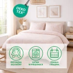 Pościel flanelowa 160x200 w kolorze pudrowego różu z białym wzorem w liście. Rozłożona na łóżku z przyjemnym oświetleniem. Poduszki w tym samym wzorze. Tło stanowi stylowe wnętrze z dekoracyjnymi elementami, takimi jak kwiaty i obraz na ścianie.